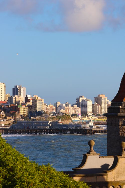 Free A sunlit view of Mar del Plata's skyline with the coastline and buildings under a blue sky. Stock Photo