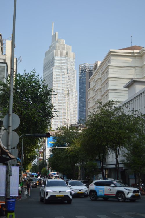 Free A bustling city street view featuring modern skyscrapers and busy traffic, under a clear blue sky. Stock Photo