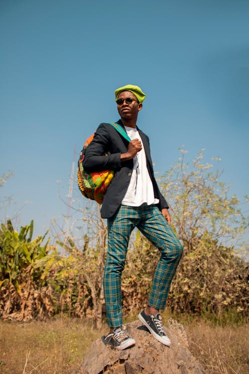 Serious Man in Blue Checkered Pants Standing on Rock