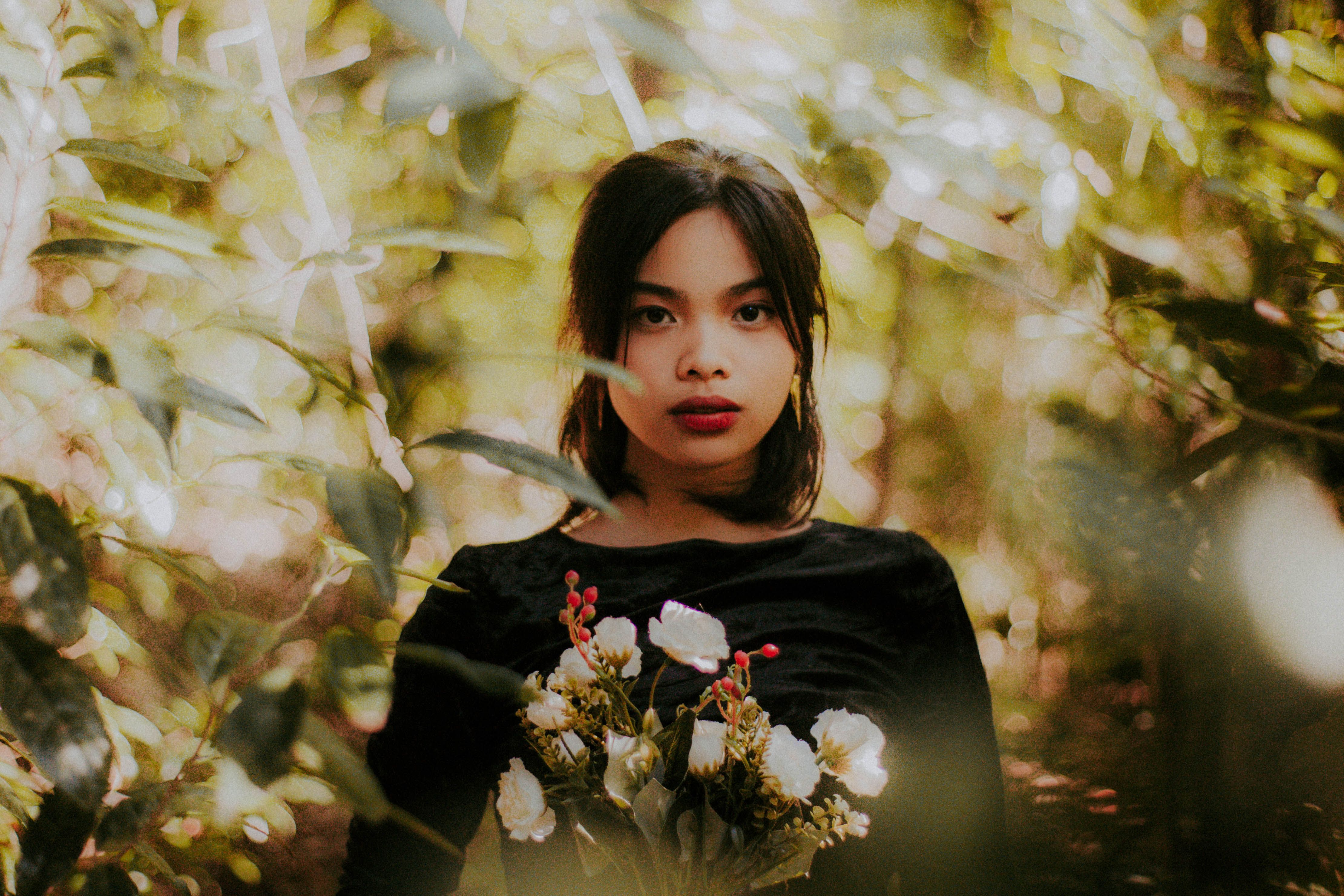 Woman in Black Crew Neck Shirt Holding Bouquet of Flowers · Free Stock ...