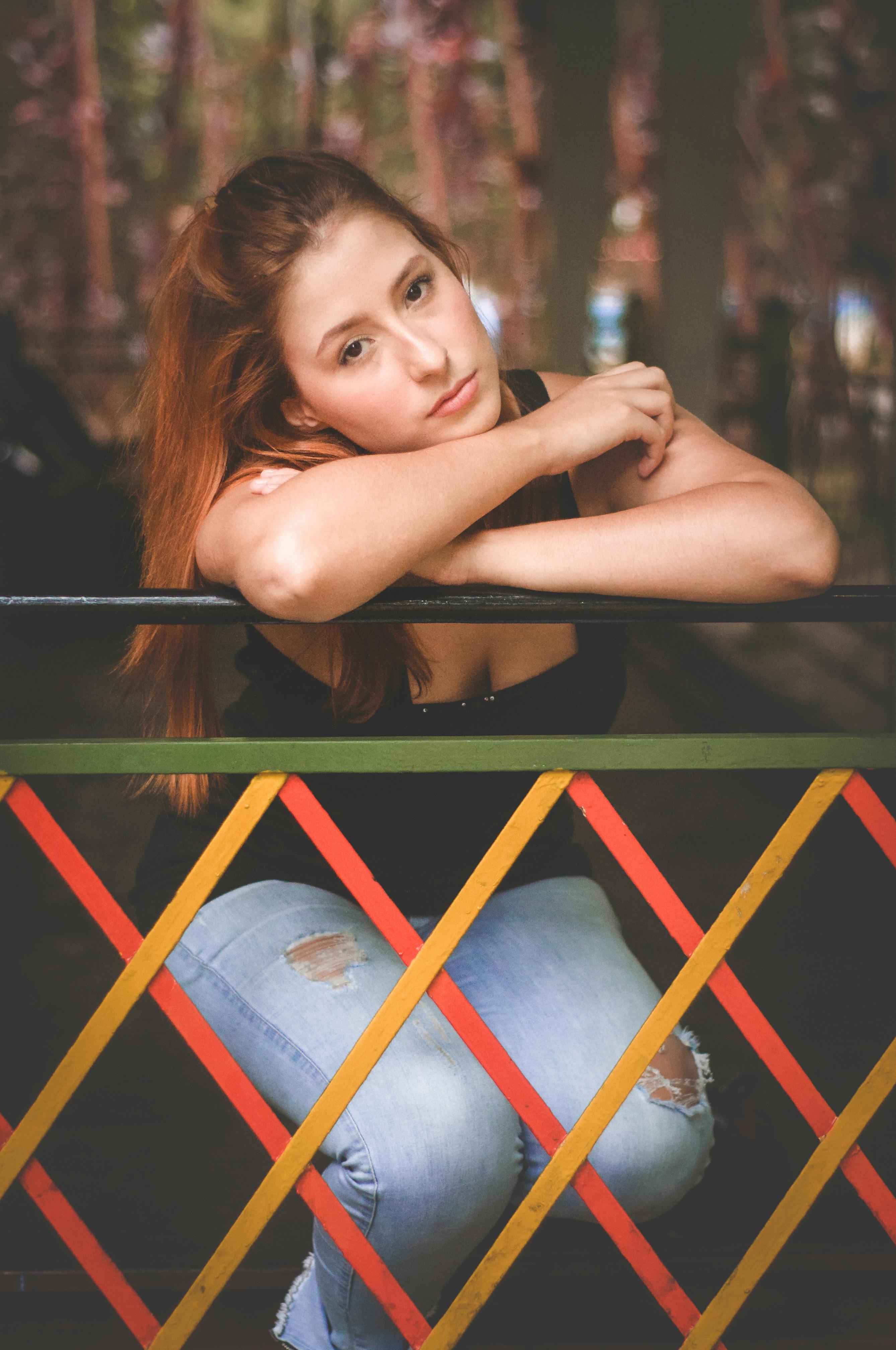 calm woman leaning on railing in city park