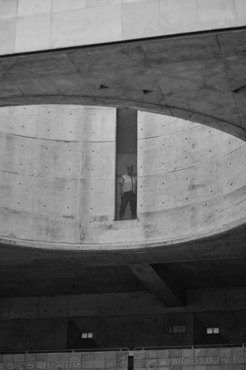 Free Silhouette of a person standing in an architectural space with circular concrete design. Stock Photo