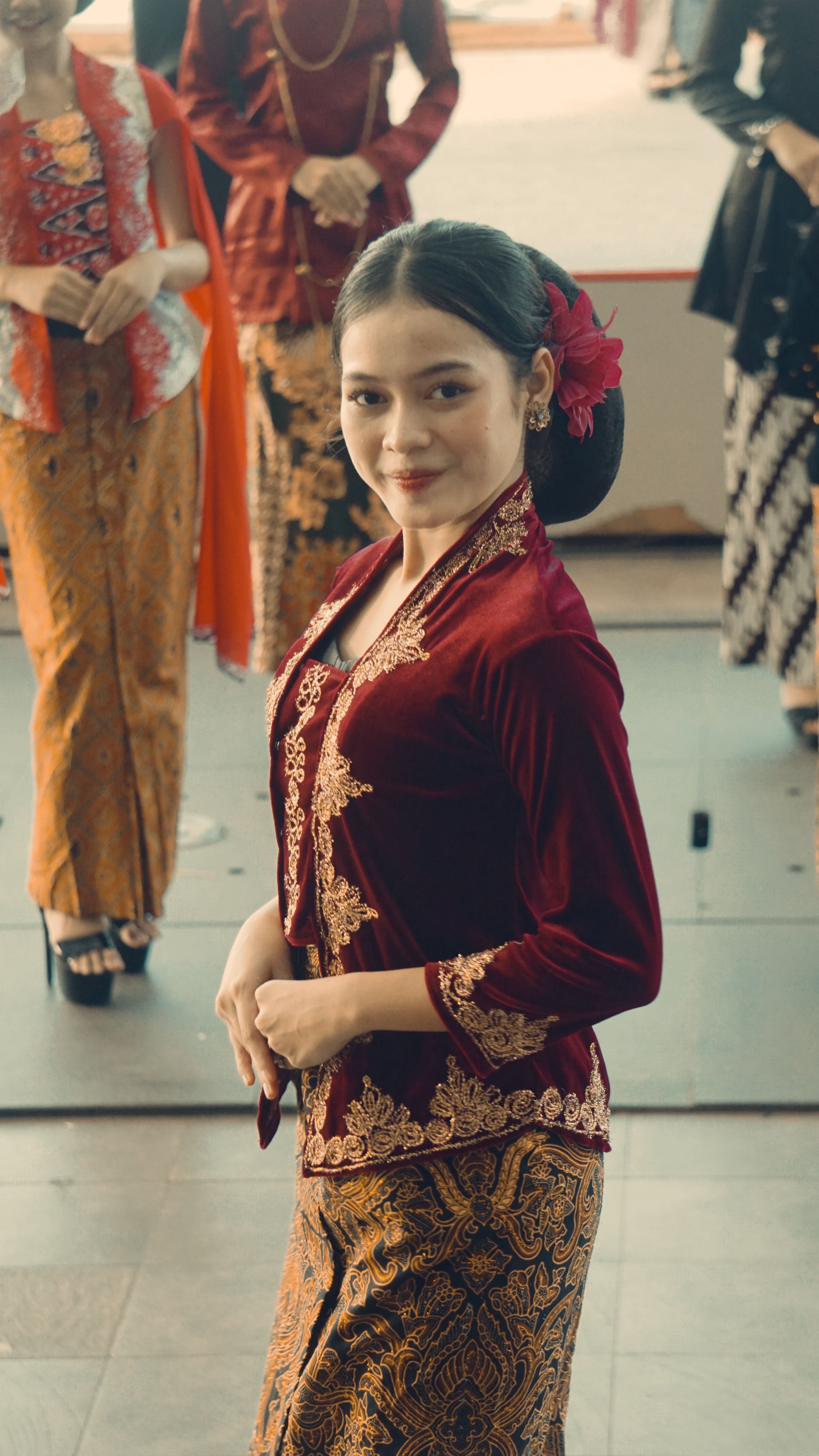 Elegant woman in traditional Indonesian attire at a fashion event in Jakarta, showcasing cultural beauty.