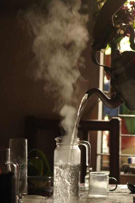 Fotomural Se vierte agua caliente en una jarra de vidrio, creando vapor en un espacio interior.