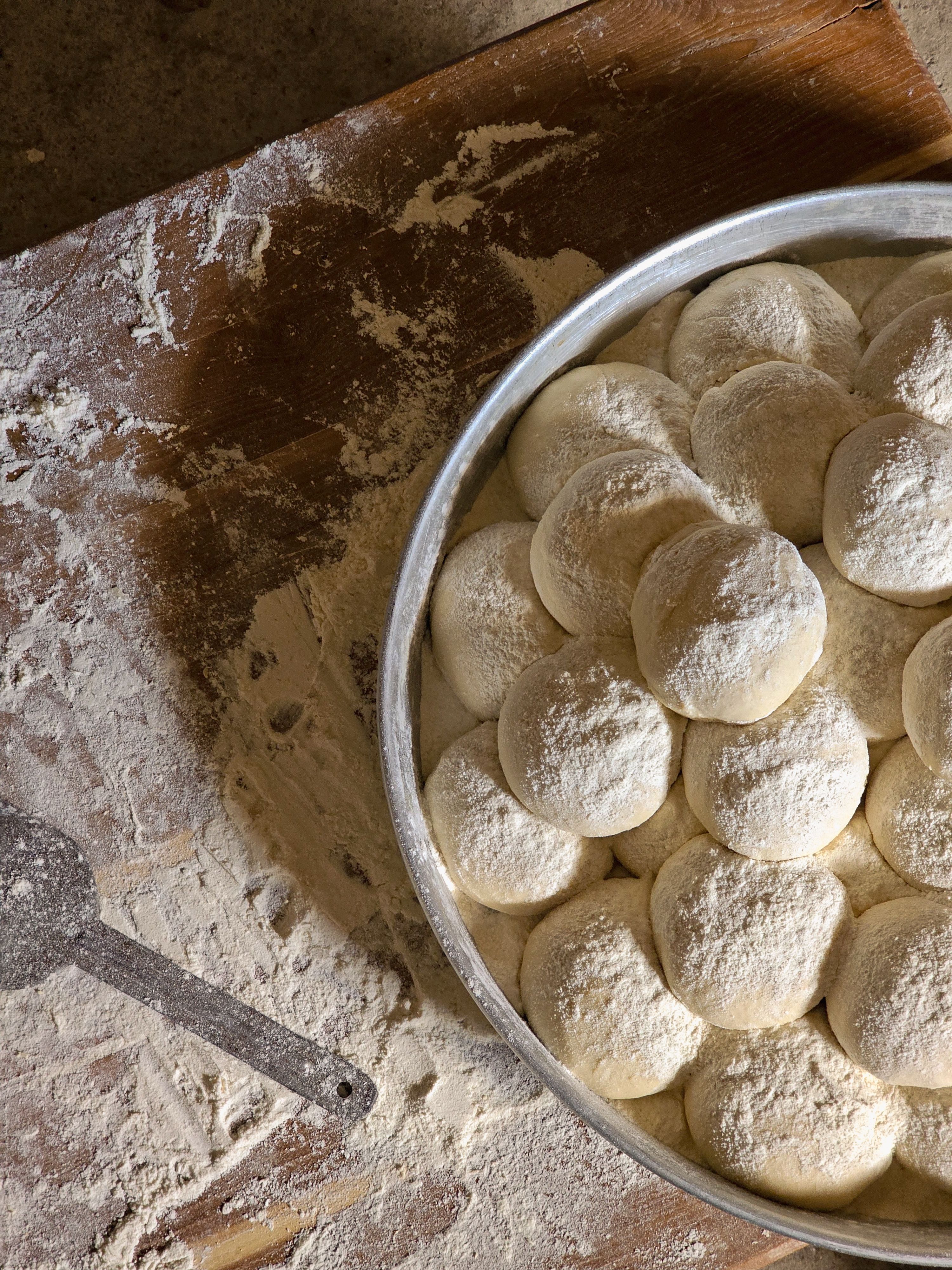 Dough balls resting on a floured surface, ideal for baking or culinary themes.