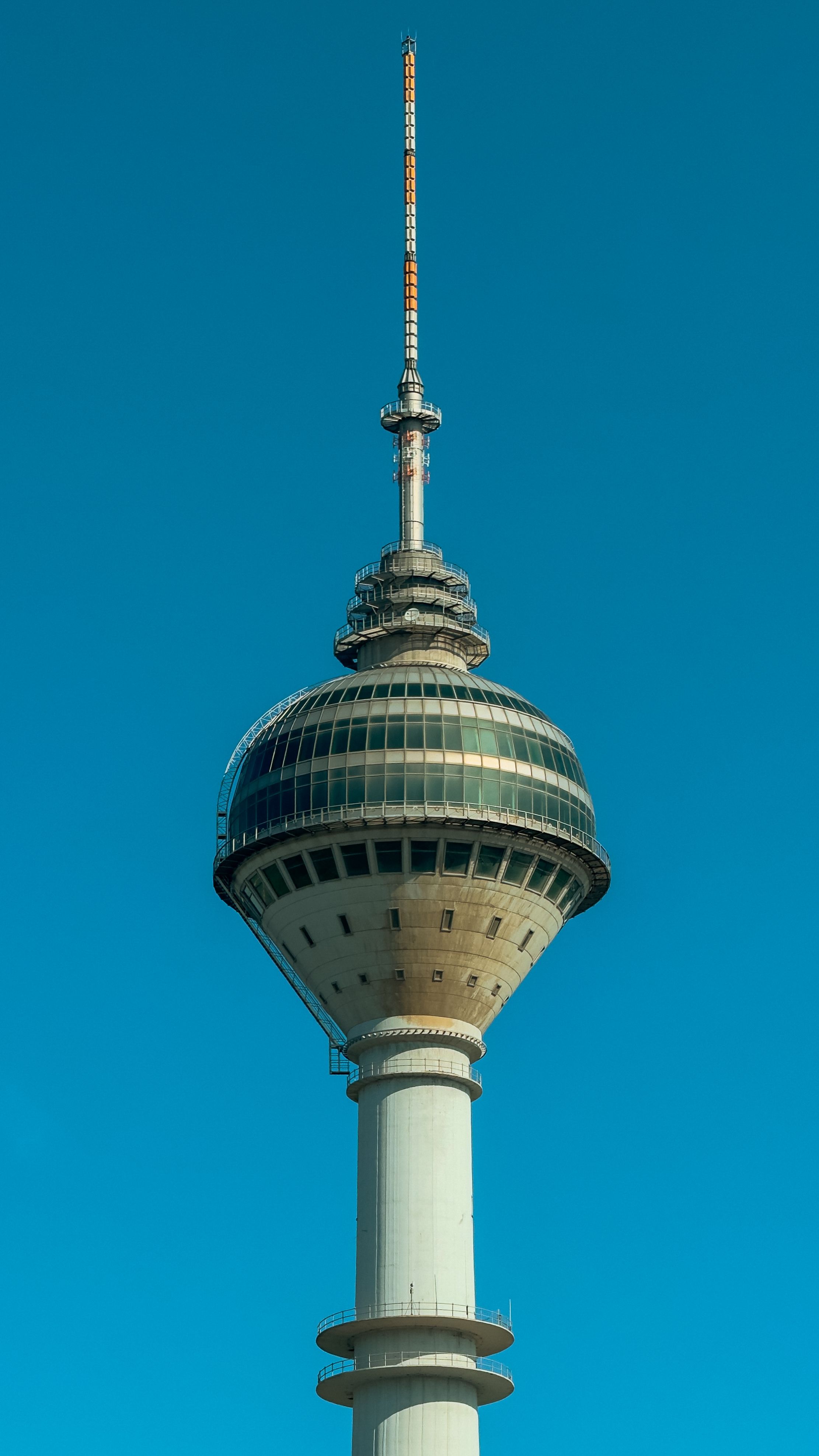 Iconic Milad Tower in Tehran captured against a vibrant blue sky, showcasing modern Iranian architecture.
