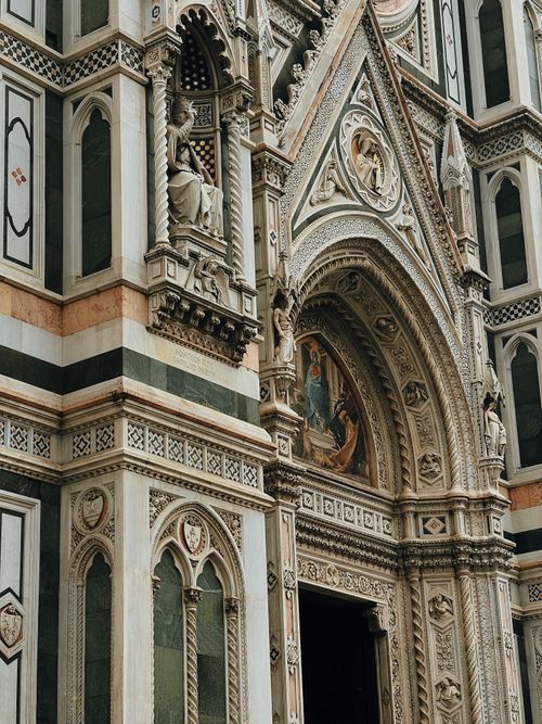 Free Detailed view of the Gothic architectural elements on the facade of Santa Maria del Fiore in Florence, Italy. Stock Photo