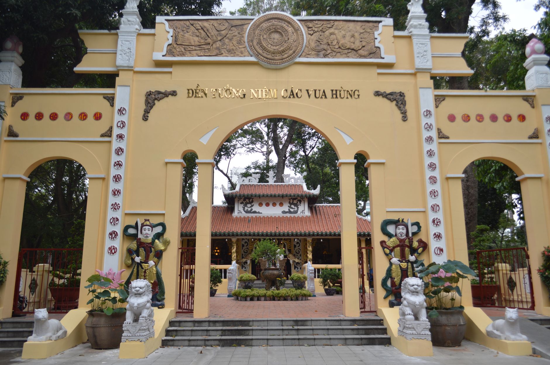 Historic temple entrance in Vietnam featuring cultural statues and vibrant architecture.