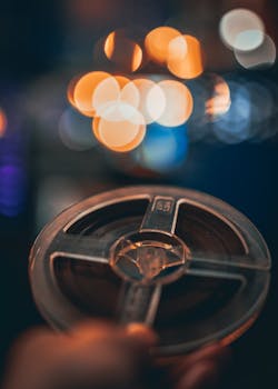 Close-up of a vintage film reel with artistic bokeh effect, creating a moody nighttime ambiance.