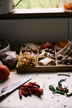 A variety of fresh vegetables and spices on a kitchen counter, ready for cooking preparation.