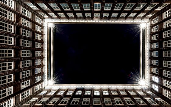 Dramatic view of Sprinkenhof's illuminated architectural symmetry in Hamburg at night.