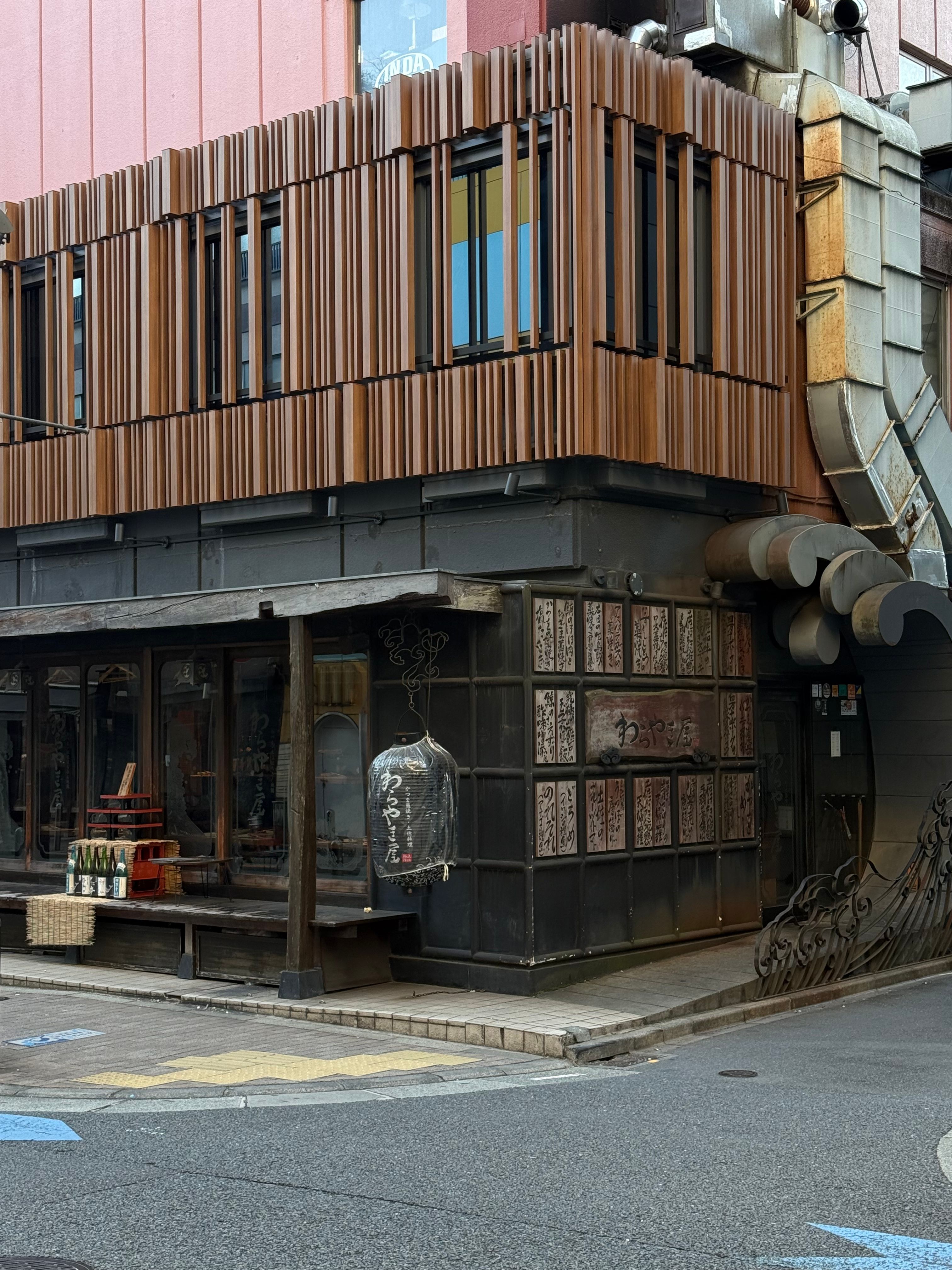 Traditional shopfront in a Japanese city showcasing wooden architecture and cultural details.