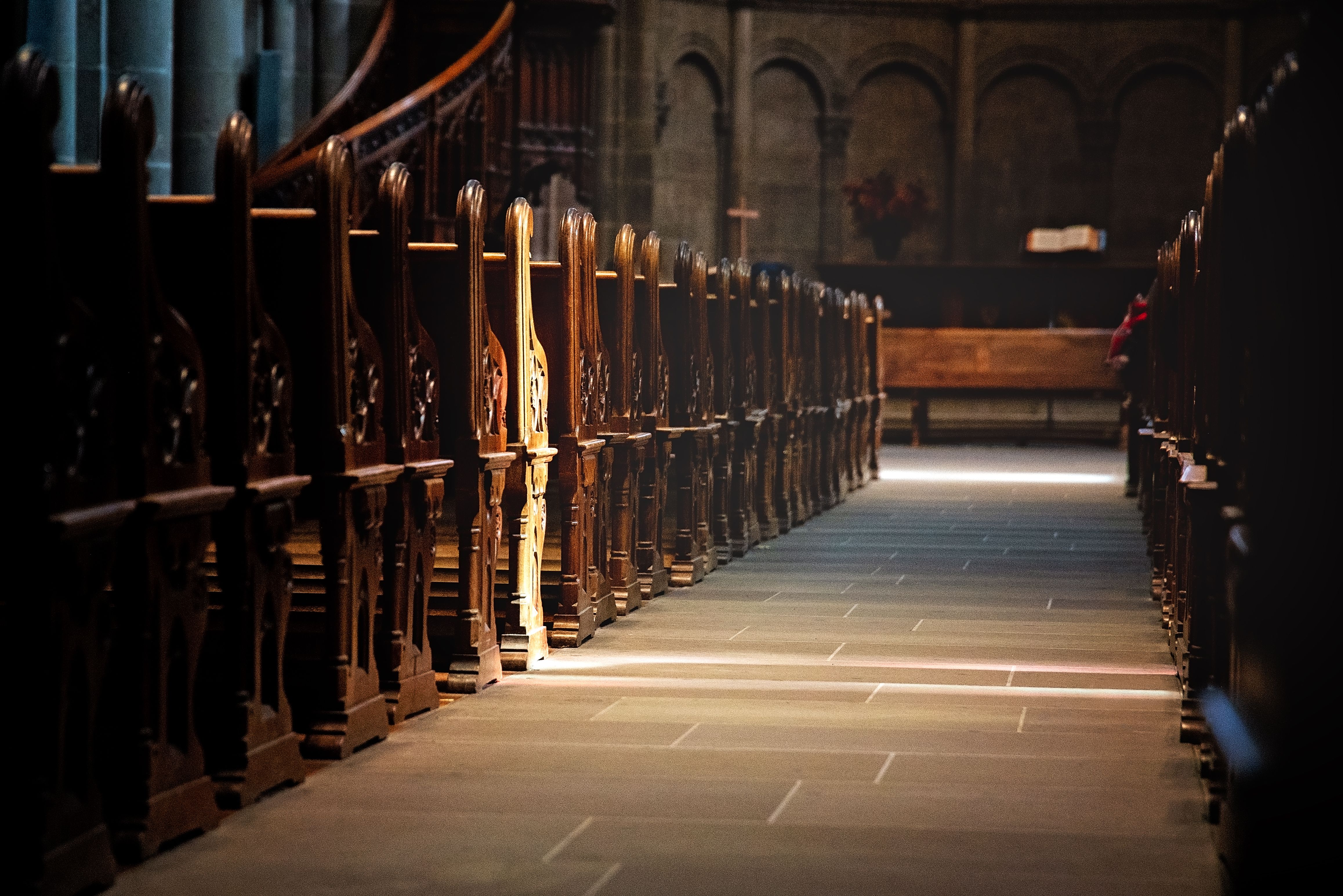A tranquil view of ornate wooden pews inside an ancient church, emphasizing spirituality.
