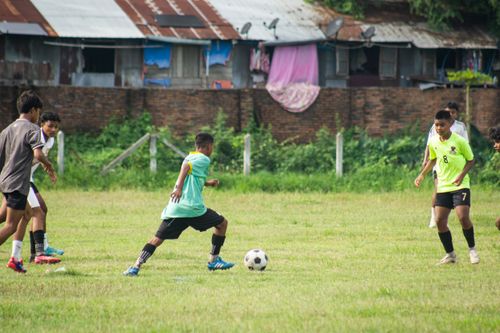 Free Young boys enjoying a soccer match on a grassy field in Myawaddy, Myanmar. Stock Photo