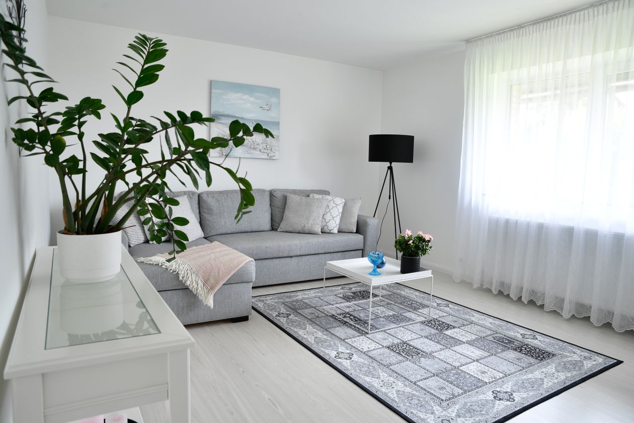 Gray sofa styled with a colorful patchwork rug and patterned cushions