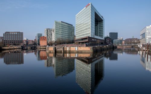 Free Reflection of modern office buildings in the calm waters of Hamburg's HafenCity, Germany. Stock Photo