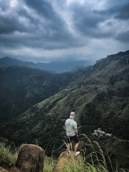 一名孤独的徒步旅行者俯瞰着云层笼罩下令人惊叹的山谷