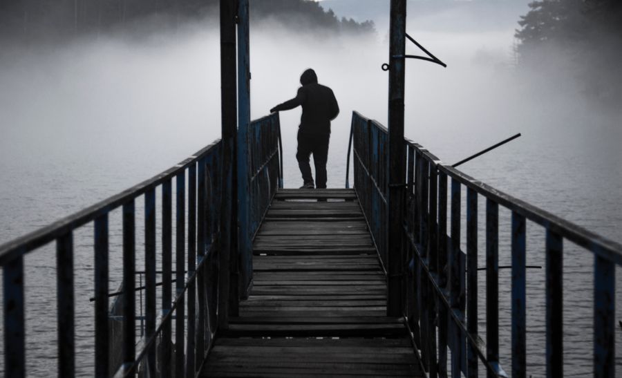 A solitary figure on a misty lakeside jetty — photo by Hikmet Toprak on Pexels