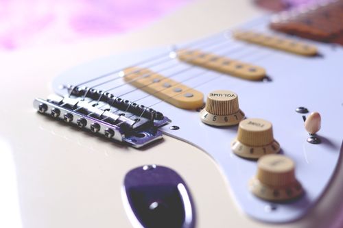 Free Detailed shot of a white vintage electric guitar, highlighting the strings, bridge, and knobs. Stock Photo