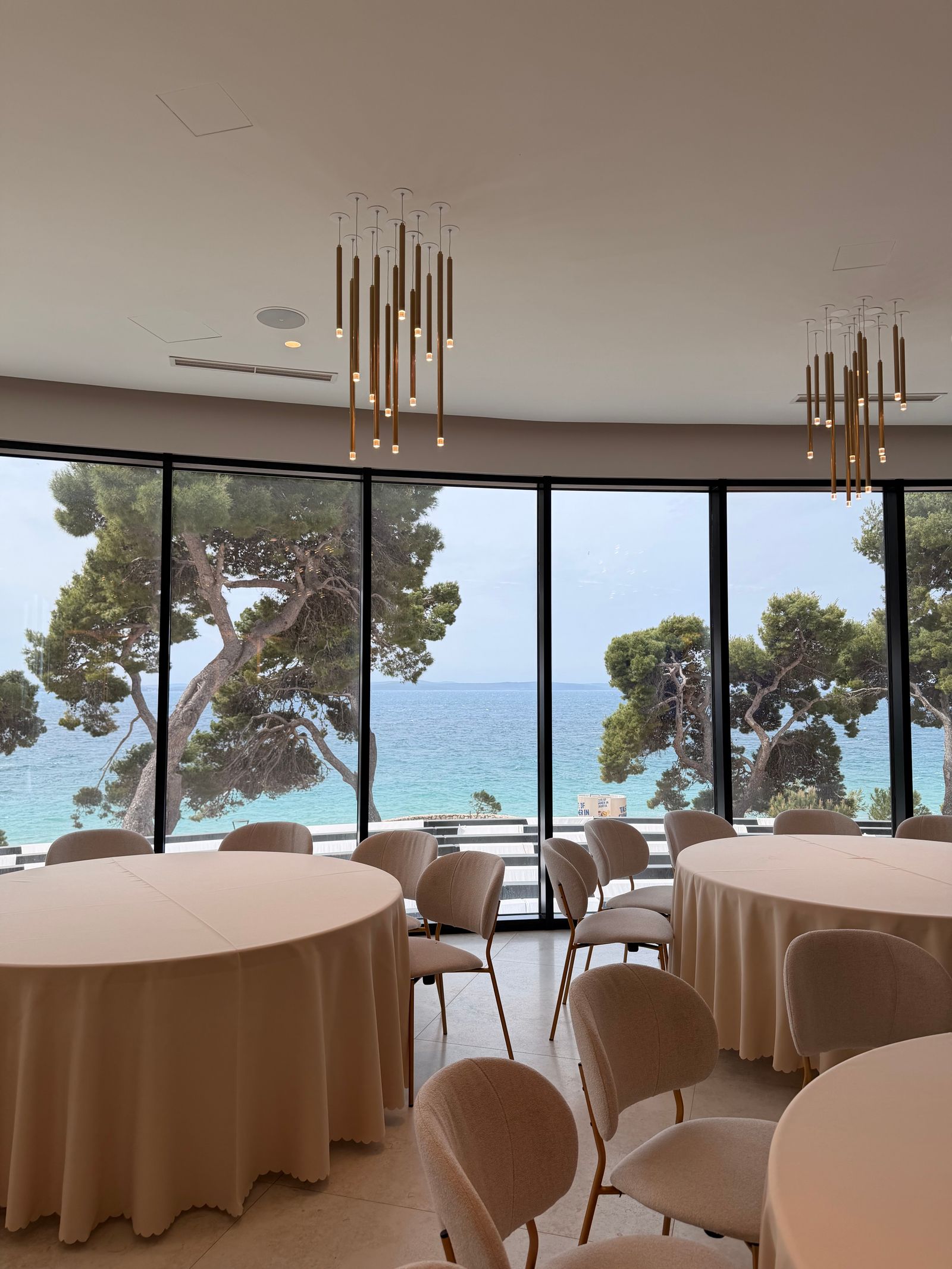 Meeting room with long table, natural light, and a wooded view.