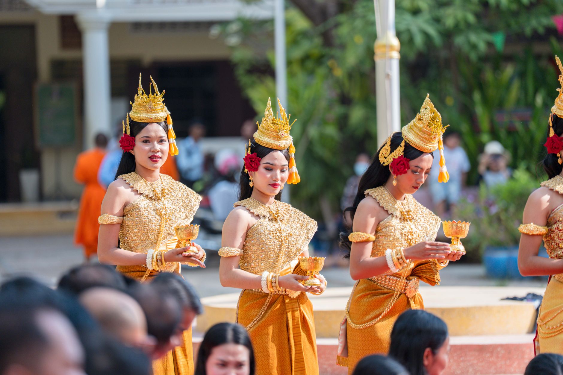 Women in traditional Cambodian costumes performing a cultural dance outdoors in Battambang Province.