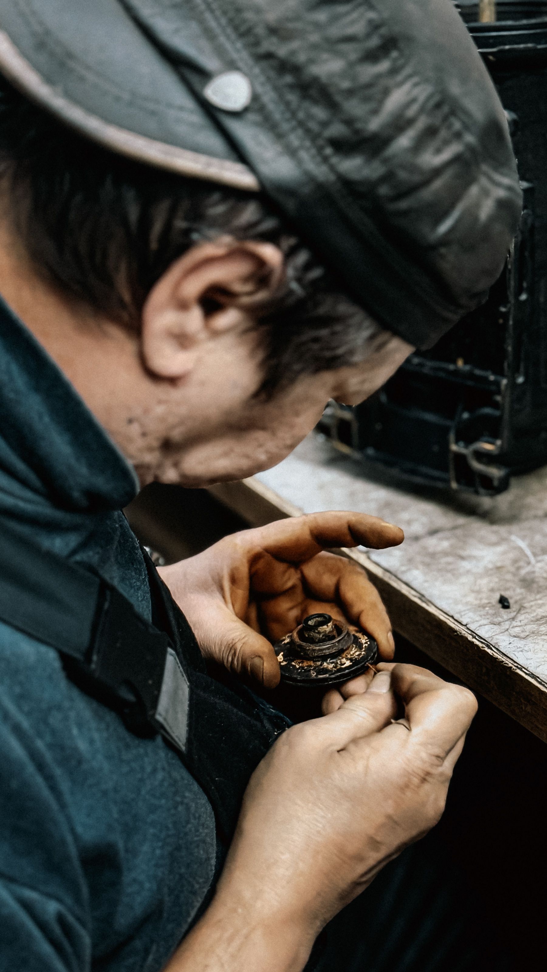 Artisan meticulously working on vintage camera parts, showcasing craftsmanship.
