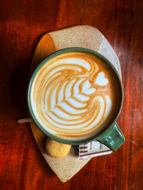 Free Aerial view of a beautifully designed latte art with heart shape, served with cookies in Hyderabad. Stock Photo