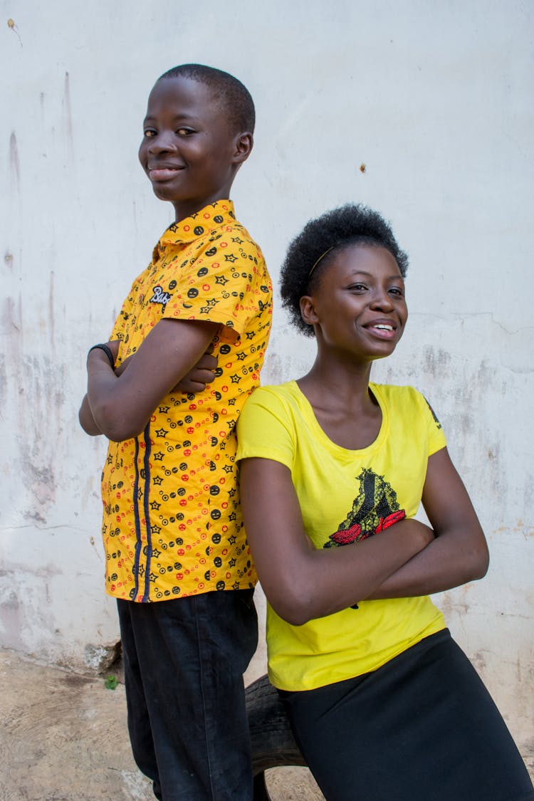 Happy African Mother And Son Against Shabby Wall