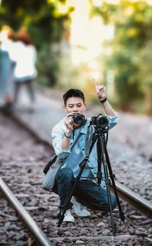 A focused photographer capturing a moment on train tracks, expressing creativity.