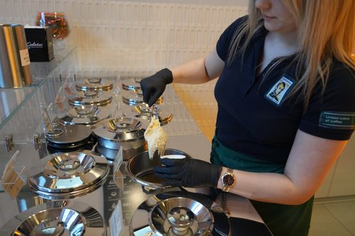 Free Barista serving gelato at a stylish cafe with a modern interior design. Stock Photo