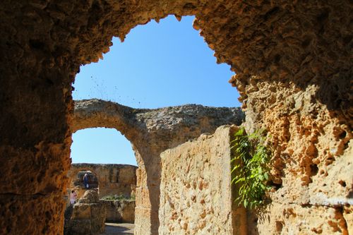 Free Discover the beauty of historical Roman ruins framed by ancient archways under a clear blue sky. Stock Photo