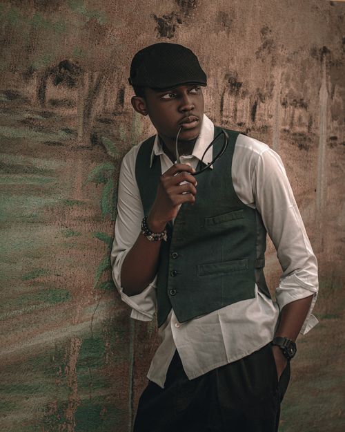Free Portrait of a young man in vintage attire with hat and glasses, exuding style and confidence. Stock Photo