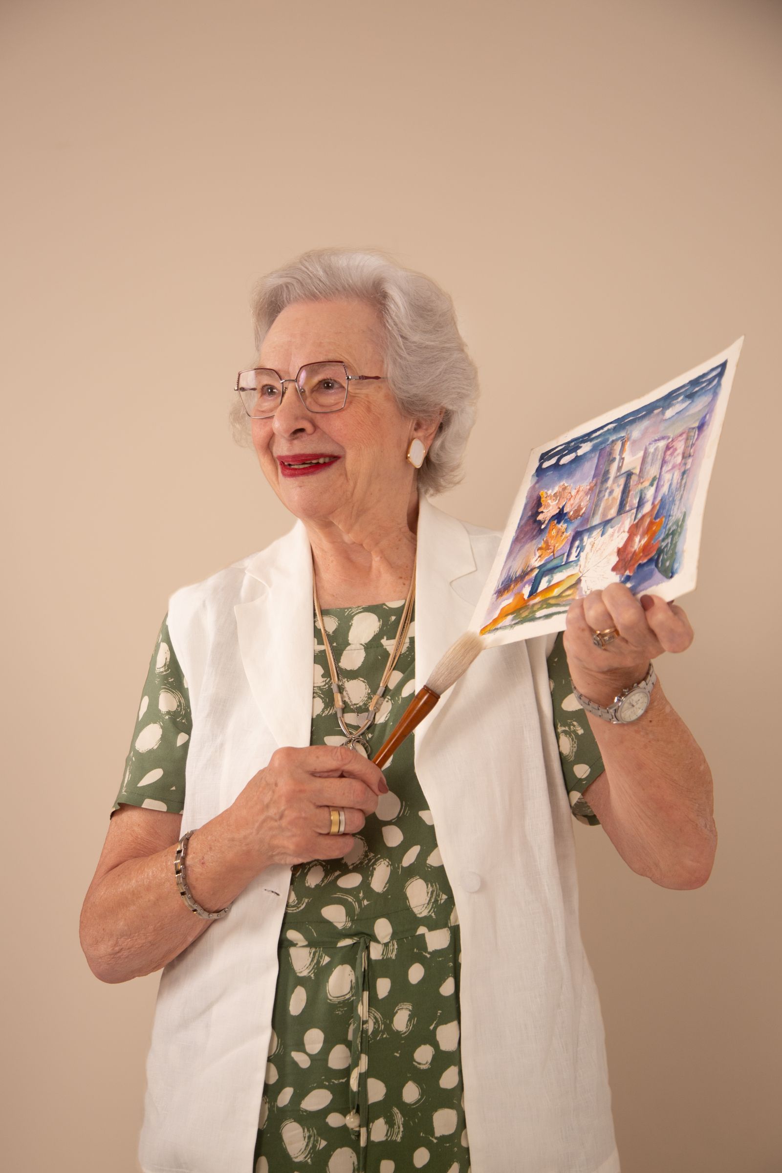 Senior resident proudly holding her painting