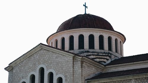 Free Elegant stone facade of a historic church with a cross-topped domed roof. Stock Photo