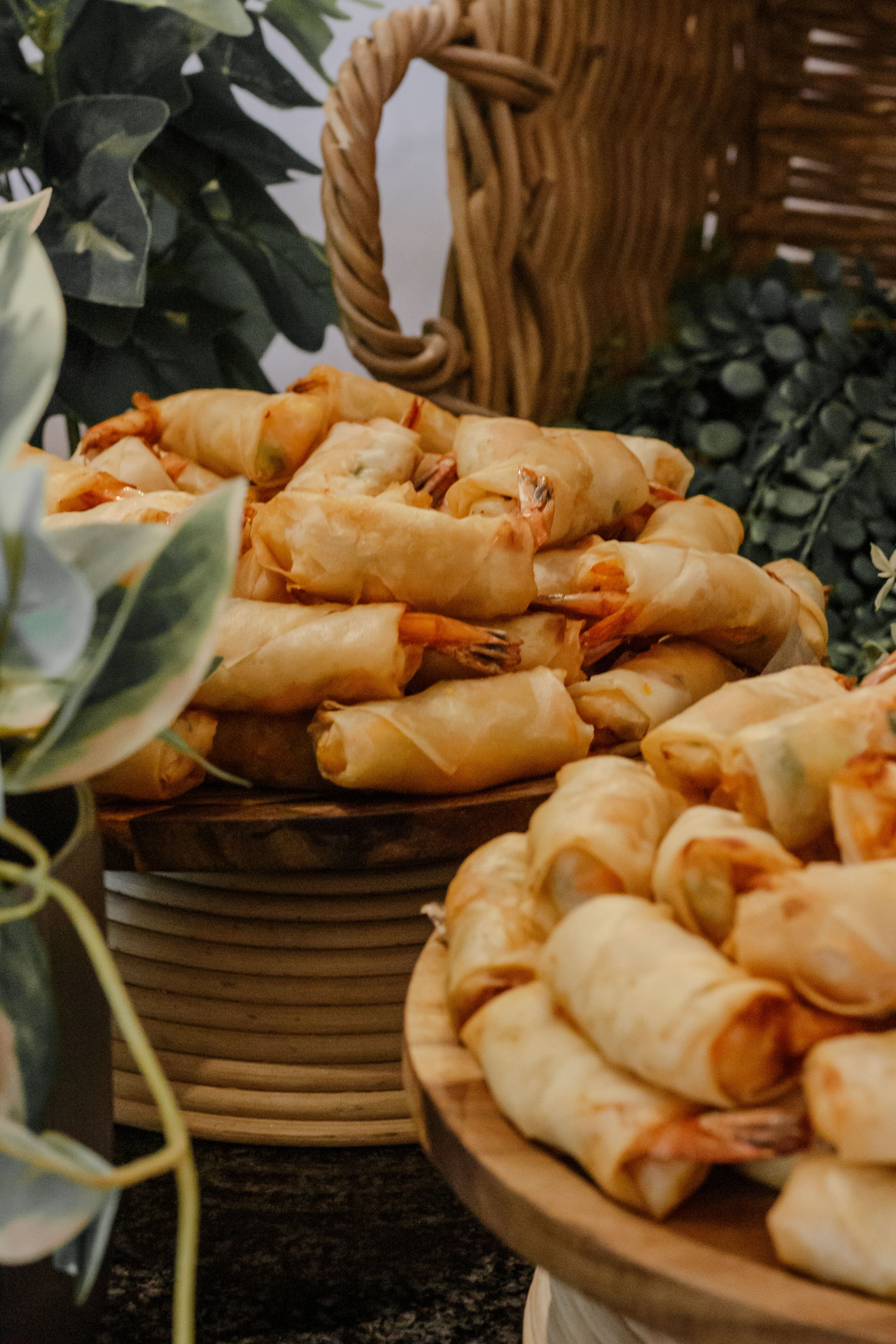 Close-up of freshly made shrimp spring rolls arranged on rustic plates.