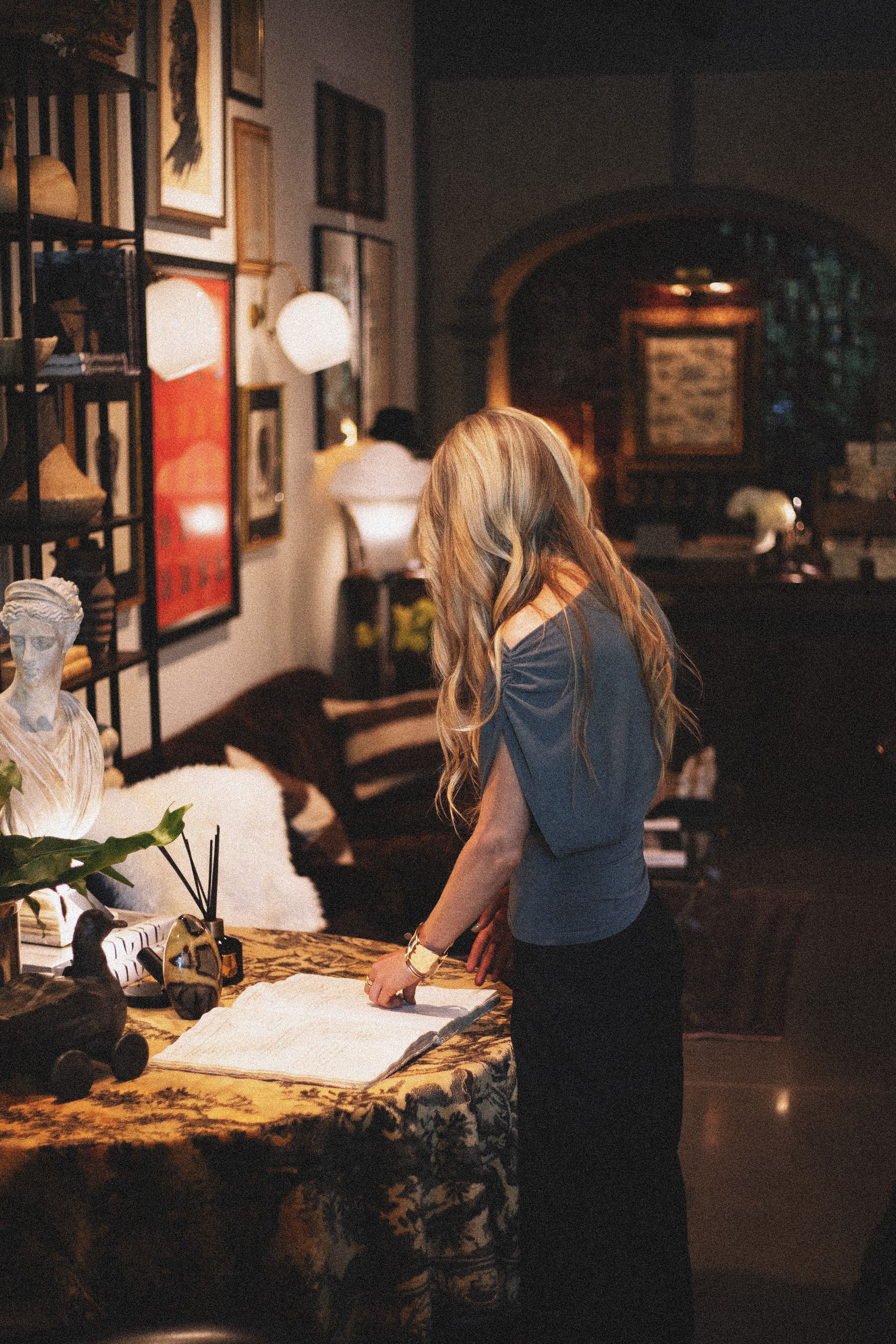 Charming boutique interior featuring vintage decor and a woman reviewing documents in a cozy setting.