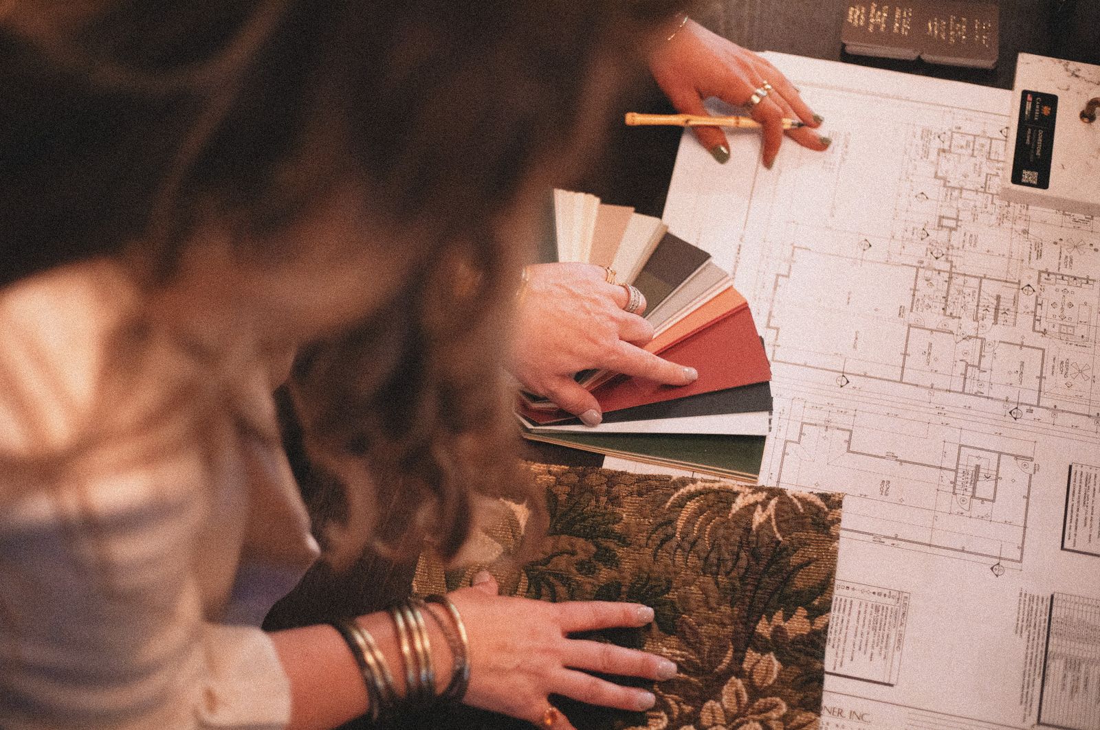 Interior designer reviewing blueprints with fabric and colour samples