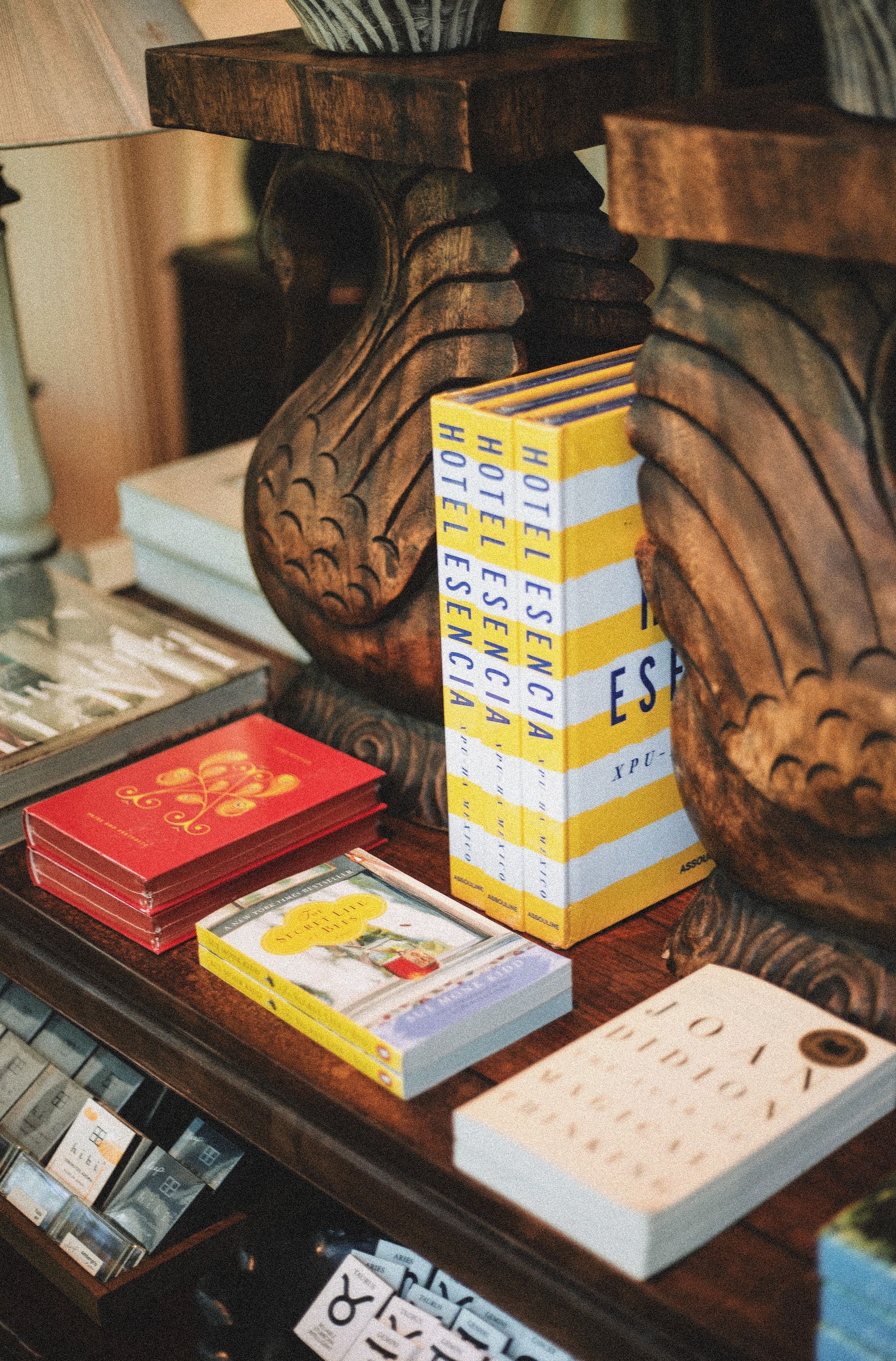 A cozy display of art and travel books on elegant wooden furniture in a Greenville boutique.