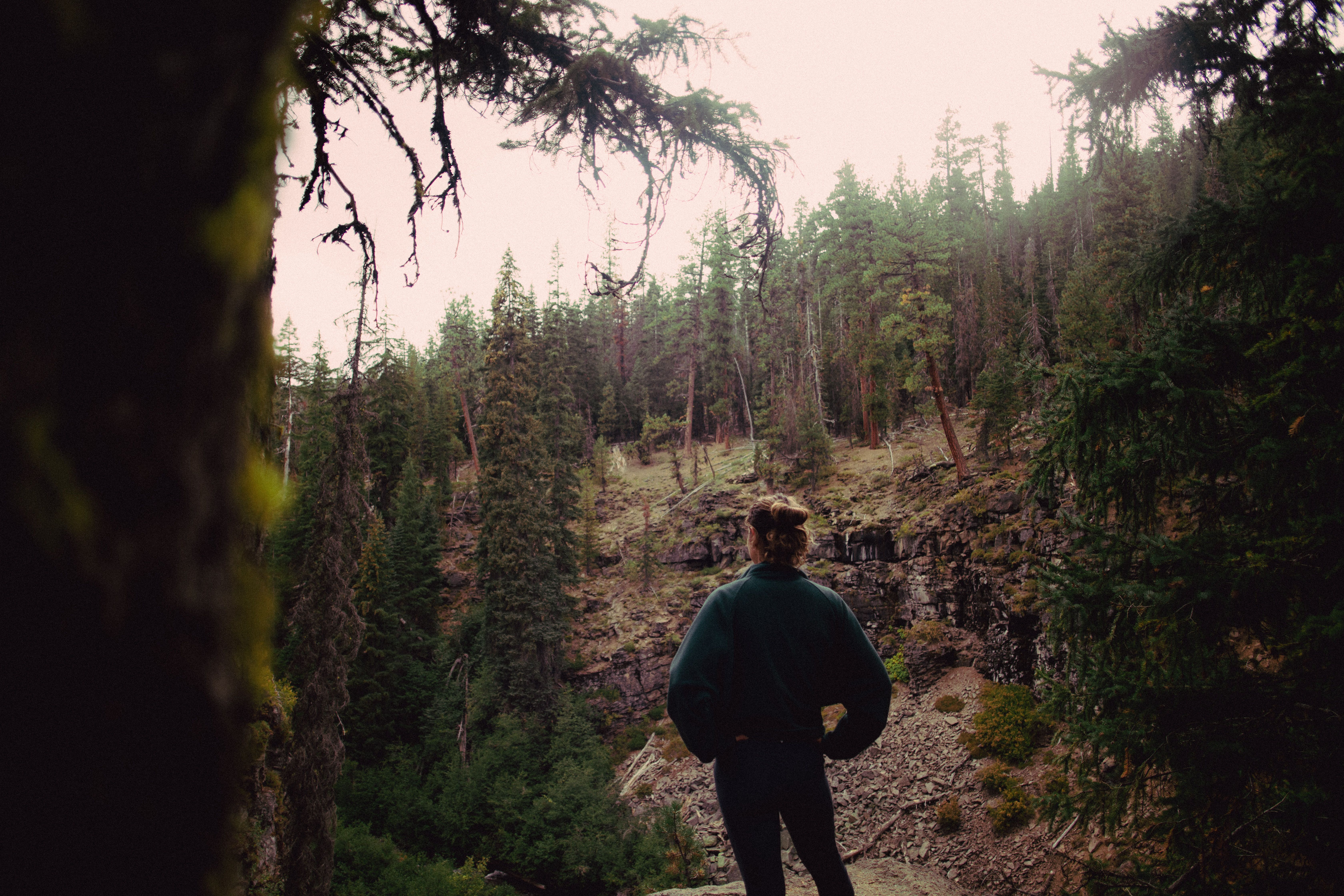 A female runner standing in front of a crossroad on a forest trail- The High-Functioning Burnout 