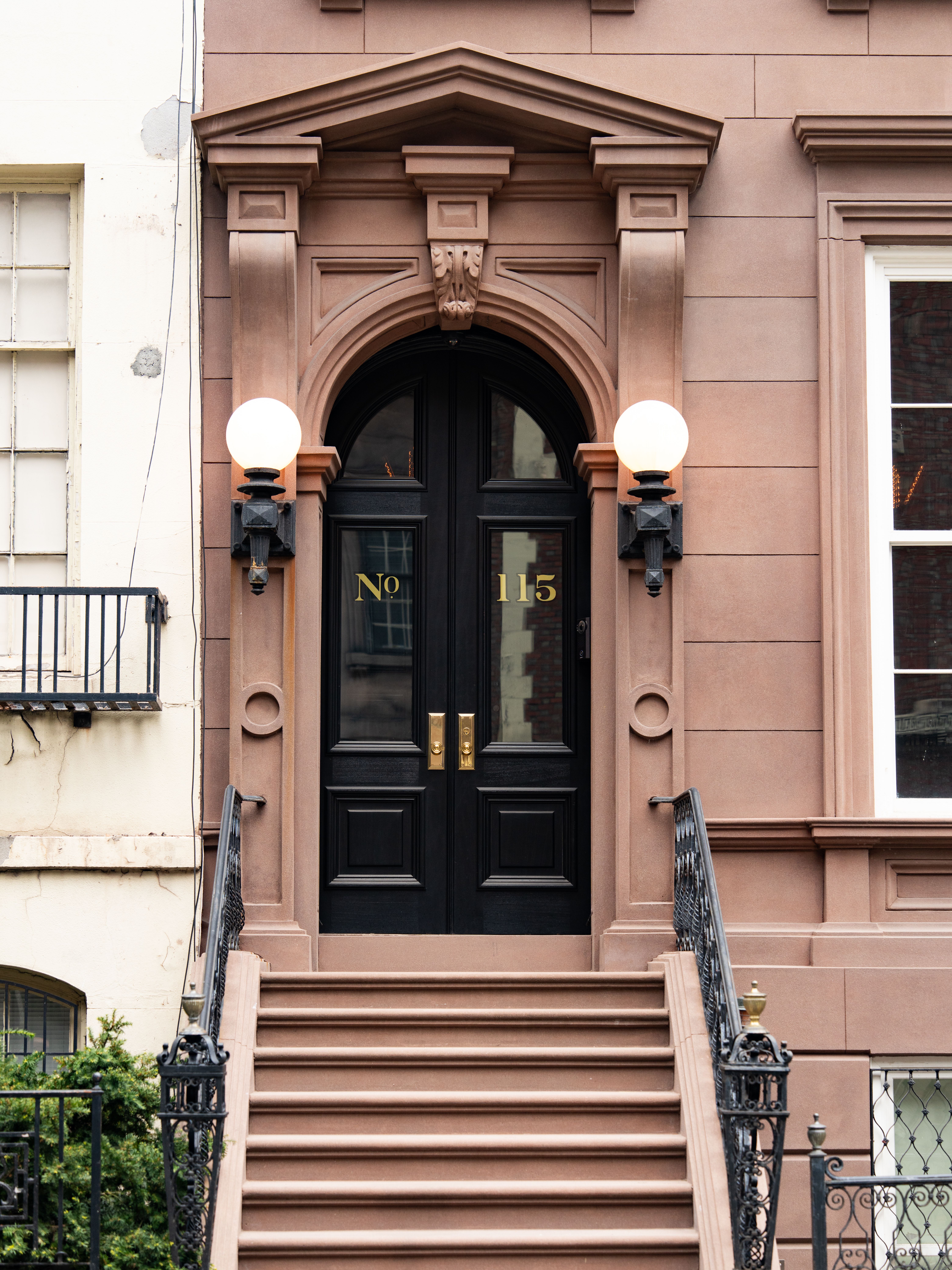 Elegant brownstone entrance with stairs in New York City, showcasing architectural beauty.