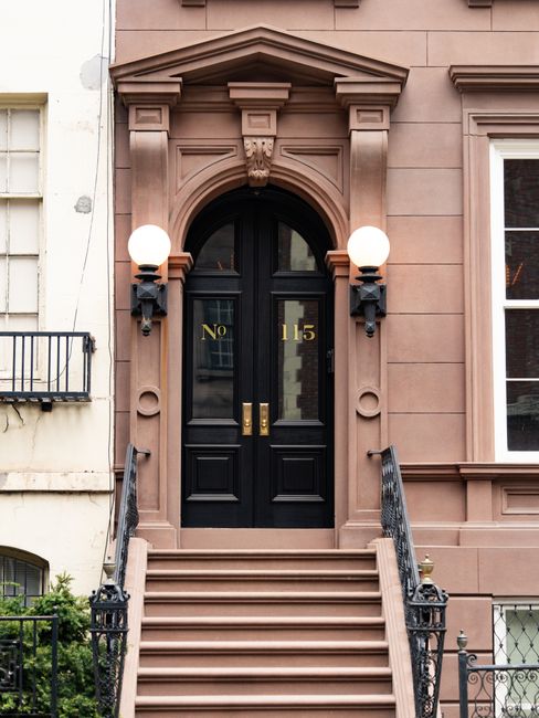 Elegant brownstone entrance with stairs in New York City, showcasing architectural beauty.