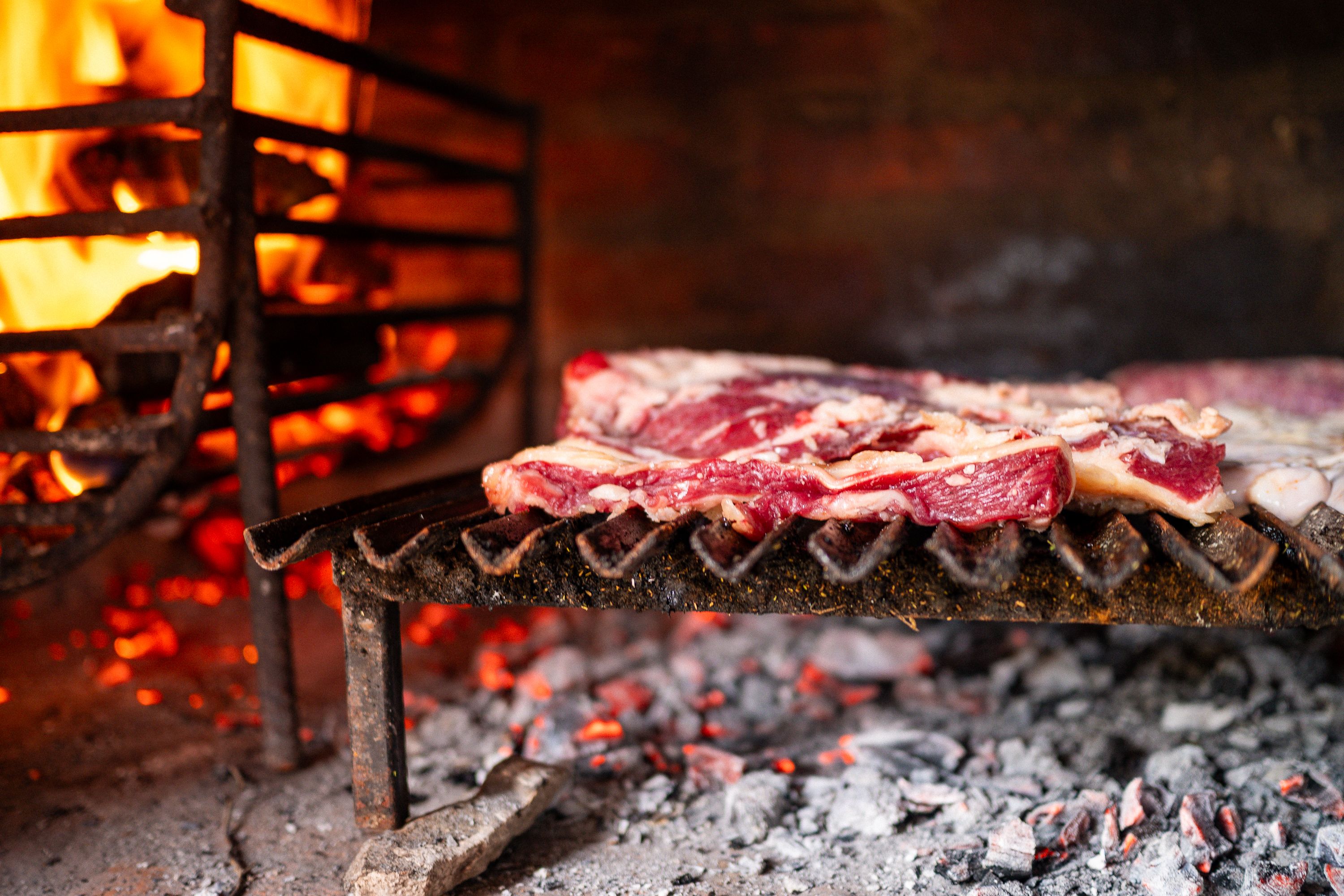 Wood-fire grilling — the traditional 4-minute-per-side cooking method.