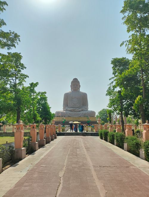 Free Majestic view of the Great Buddha statue in Bodh Gaya with surrounding greenery on a sunny day. Stock Photo