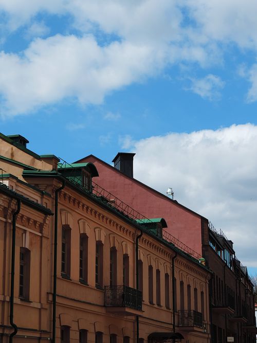 Free Colorful historic buildings under a bright blue sky with scattered clouds. Stock Photo