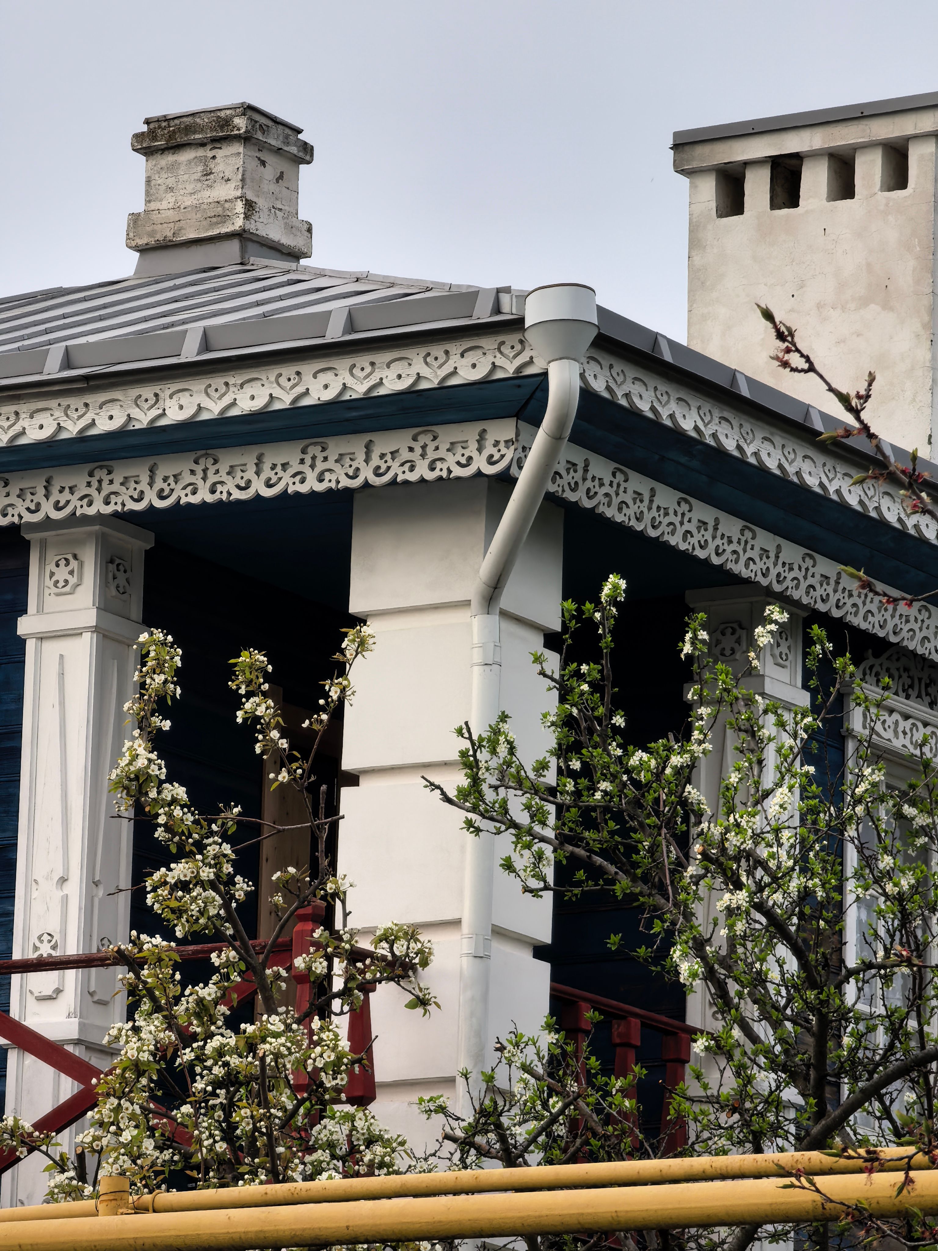 Roofline corner showing a downspout outlet on a home