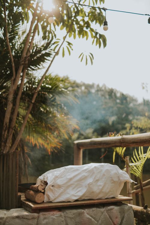 Free Tranquil outdoor campsite setup featuring firewood and lush greenery under sunlight. Stock Photo