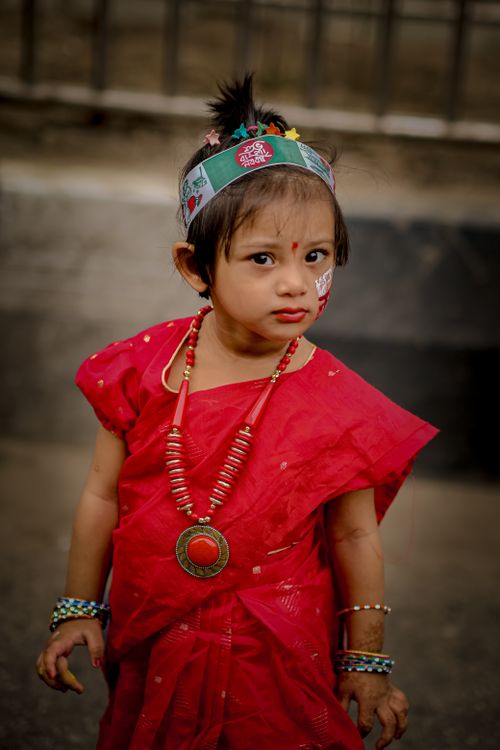 Free A child in vibrant traditional dress participates in a cultural festival outdoors. Stock Photo