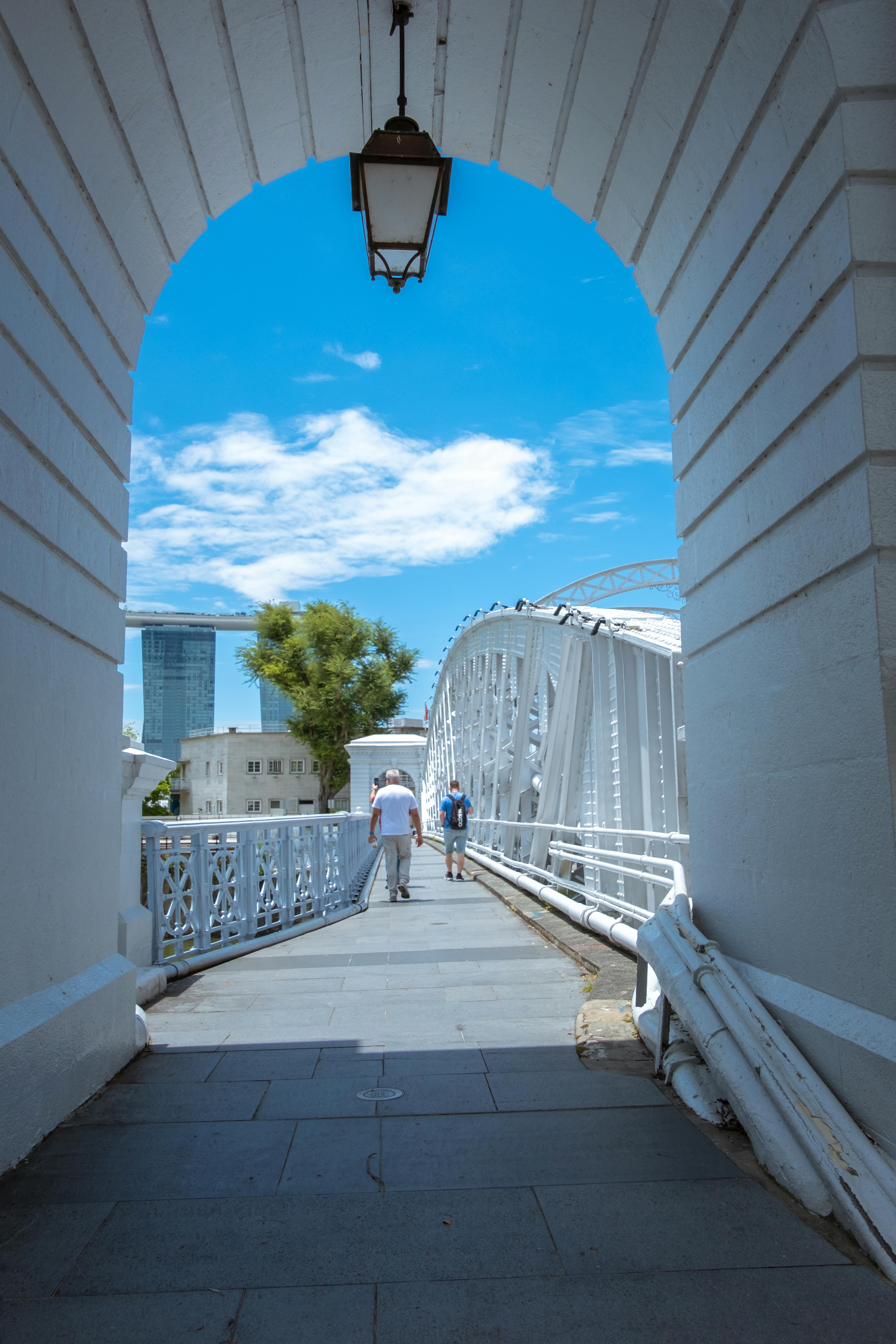 Capture of Singapore's iconic Anderson Bridge with blue sky and two pedestrians.