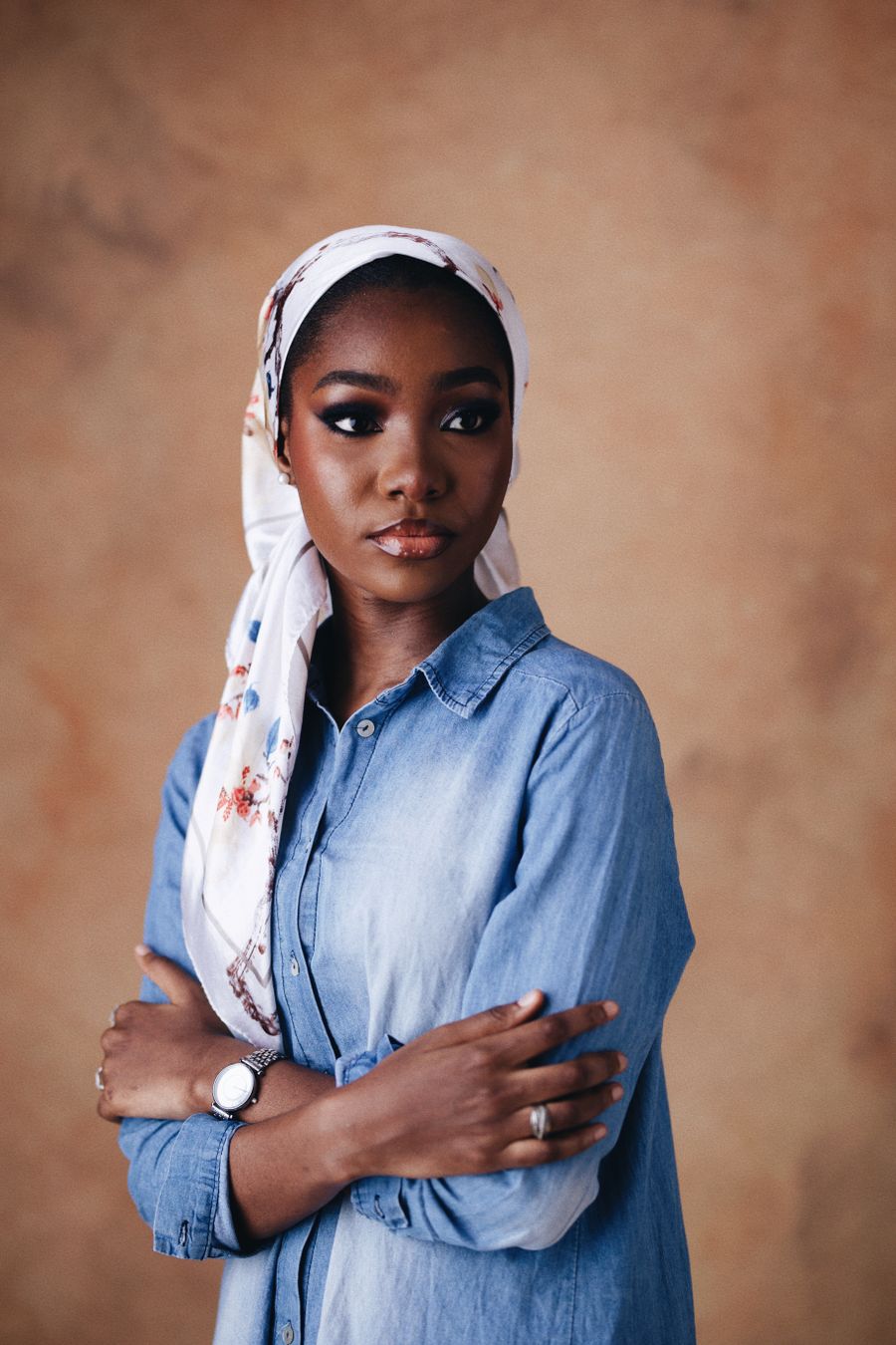 Elegant fashion model wearing a denim shirt in a polished editorial portrait