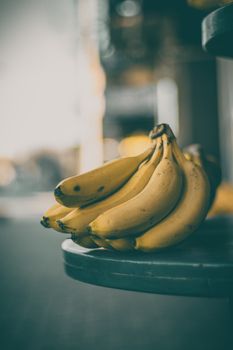 A bunch of ripe bananas on a table, captured with a moody tone in Bursa, Türkiye.